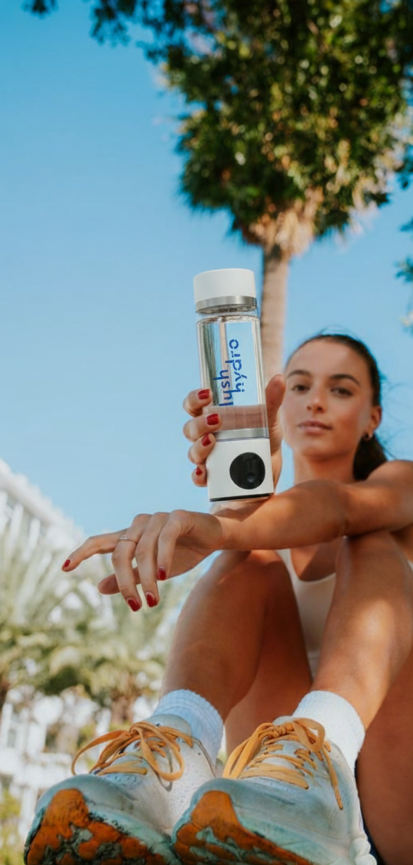 Woman holding a water bottle with a palm tree in the background